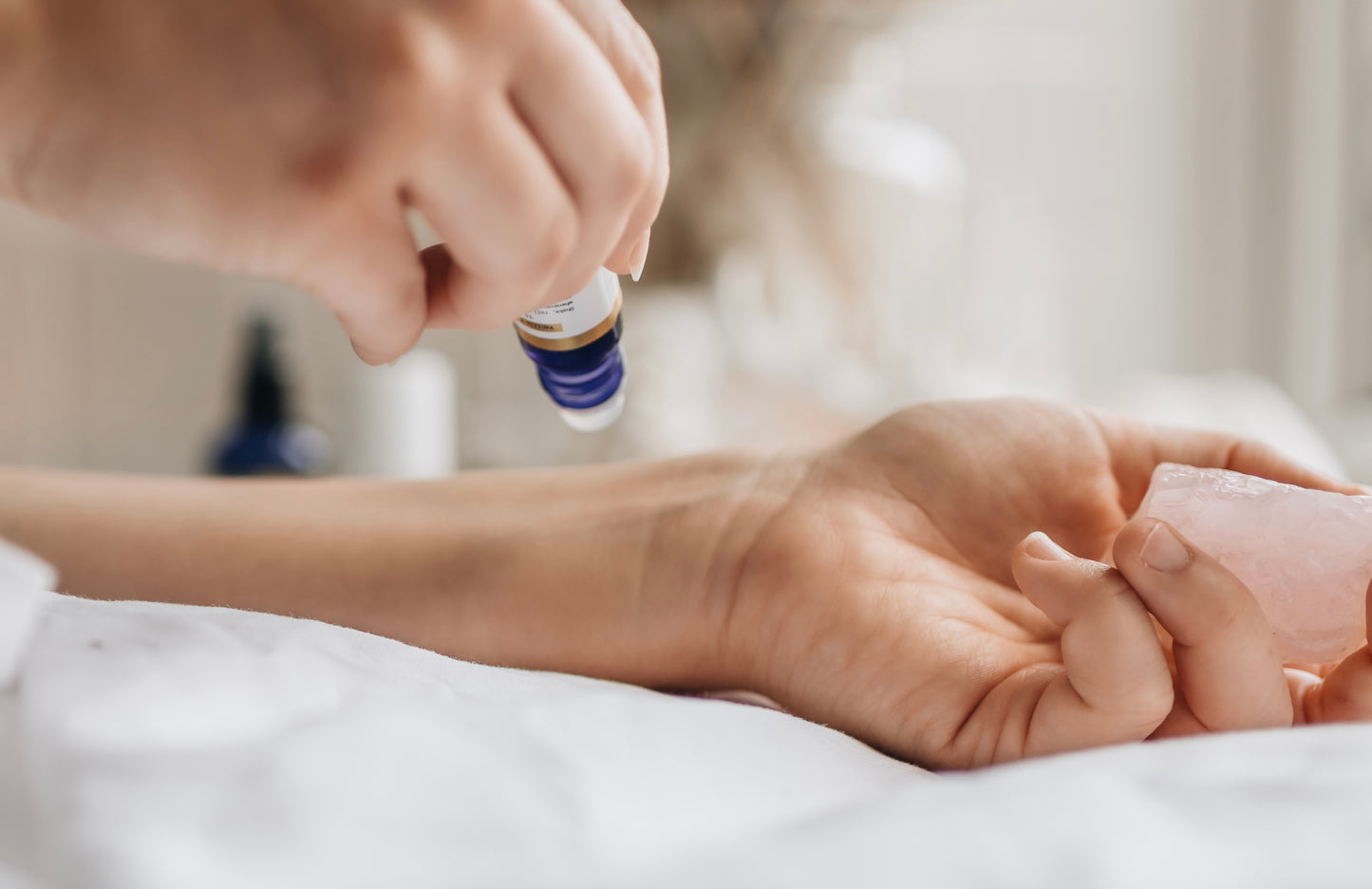 Essential oil roller being used on one wrist for calming and relaxation, natural magnesium oil and essential oil blend to soothe anxious feelings