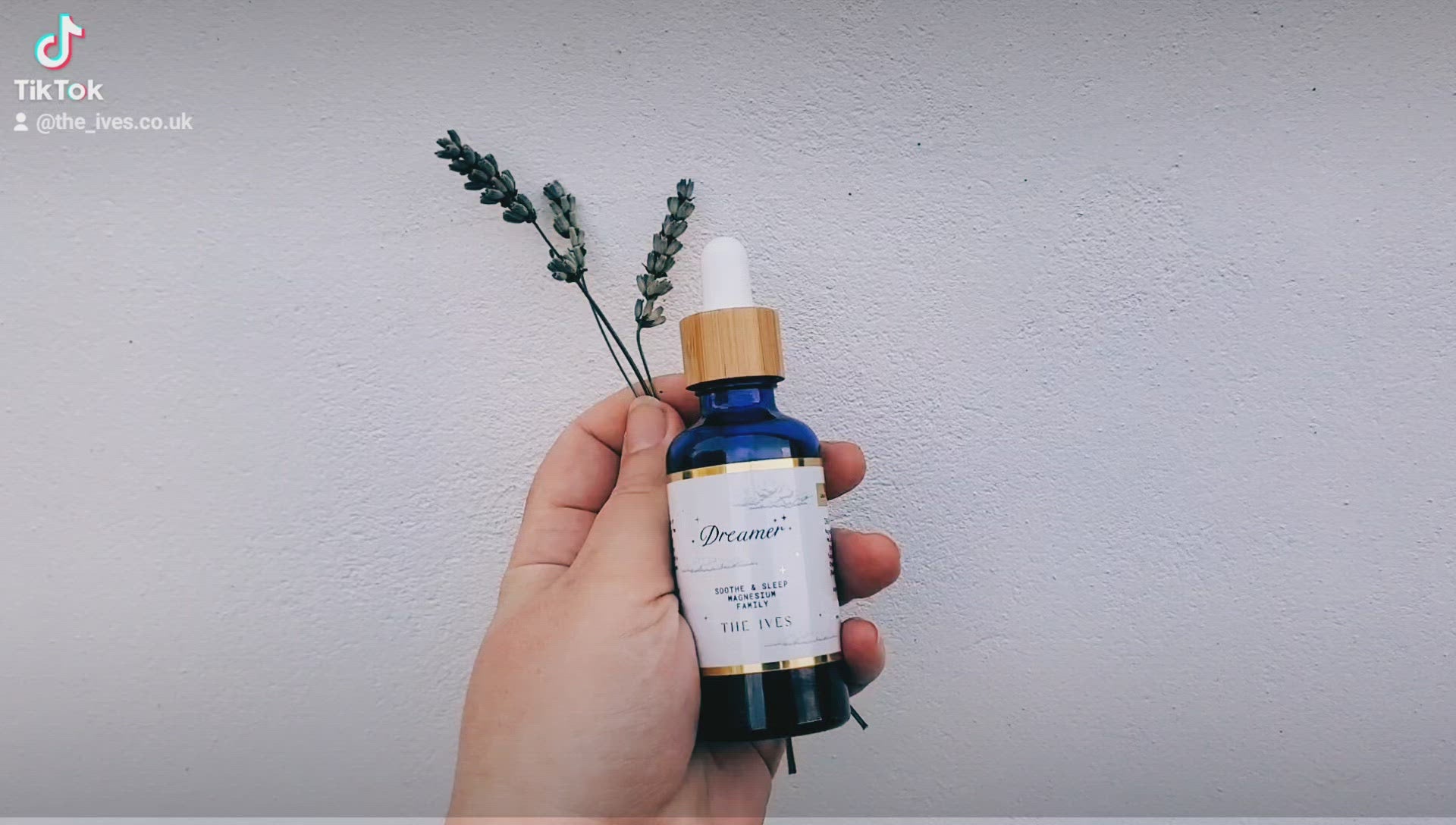 Magnesium for sleep dropper bottle being held in hand and turned with fresh lavender held in hand sleep better The Ives, theives.co.uk